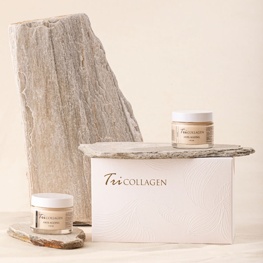 TriCollagen veido kremai du buteliukai dieninis ir naktinis šalia stovi didele pakuote ir akmensys