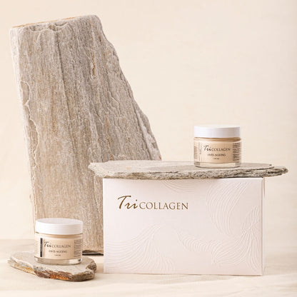 TriCollagen veido kremai du buteliukai dieninis ir naktinis šalia stovi didele pakuote ir akmensys